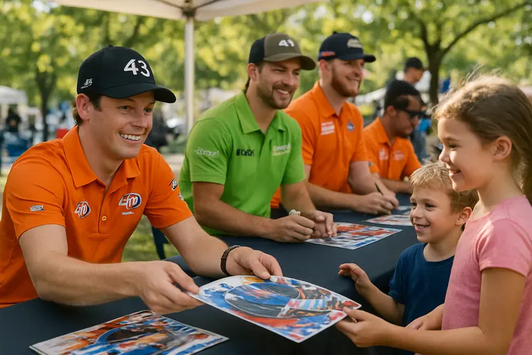 Racing team members and family supporters gathered near a garage stall